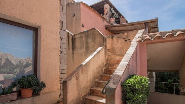 A staircase leading to a balcony with potted plants. - Cozy and bright 80 square meters apartment, perfect for four people, located on the first floor of a condominium with a swimming pool (no elevator).The property is located in Liscia di Vacca, a short distance from Porto Cervo, reachable by car or public  (Liscia di Vacca)