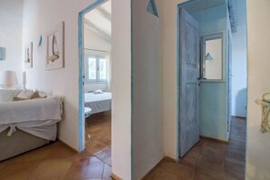 Une chambre à coucher avec un lit, une table de chevet et une fenêtre.