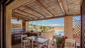 An outdoor kitchen with a view, wooden furniture, and a pergola. - Cozy and bright 80 square meters apartment, perfect for four people, located on the first floor of a condominium with a swimming pool (no elevator).The property is located in Liscia di Vacca, a short distance from Porto Cervo, reachable by car or public  (Liscia di Vacca)