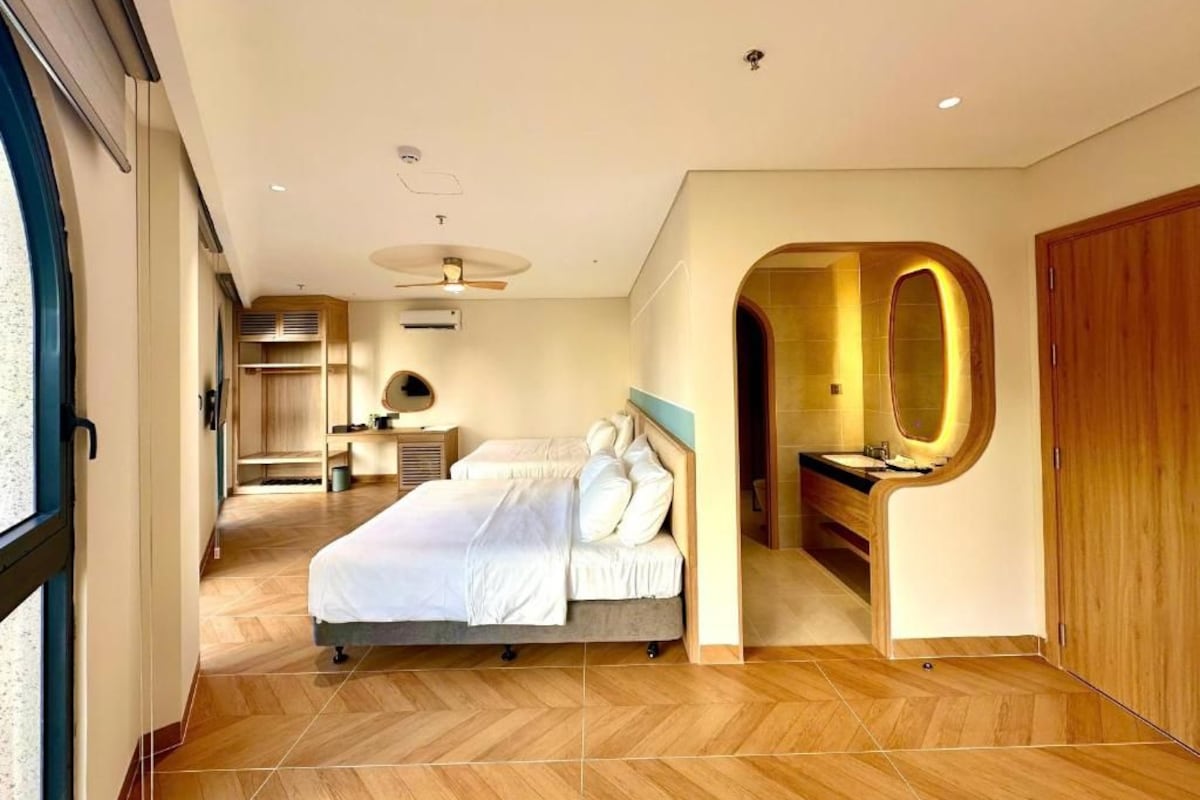 Ein modernes Schlafzimmer mit einem Bett, einem Schminktisch und einem begehbaren Kleiderschrank.