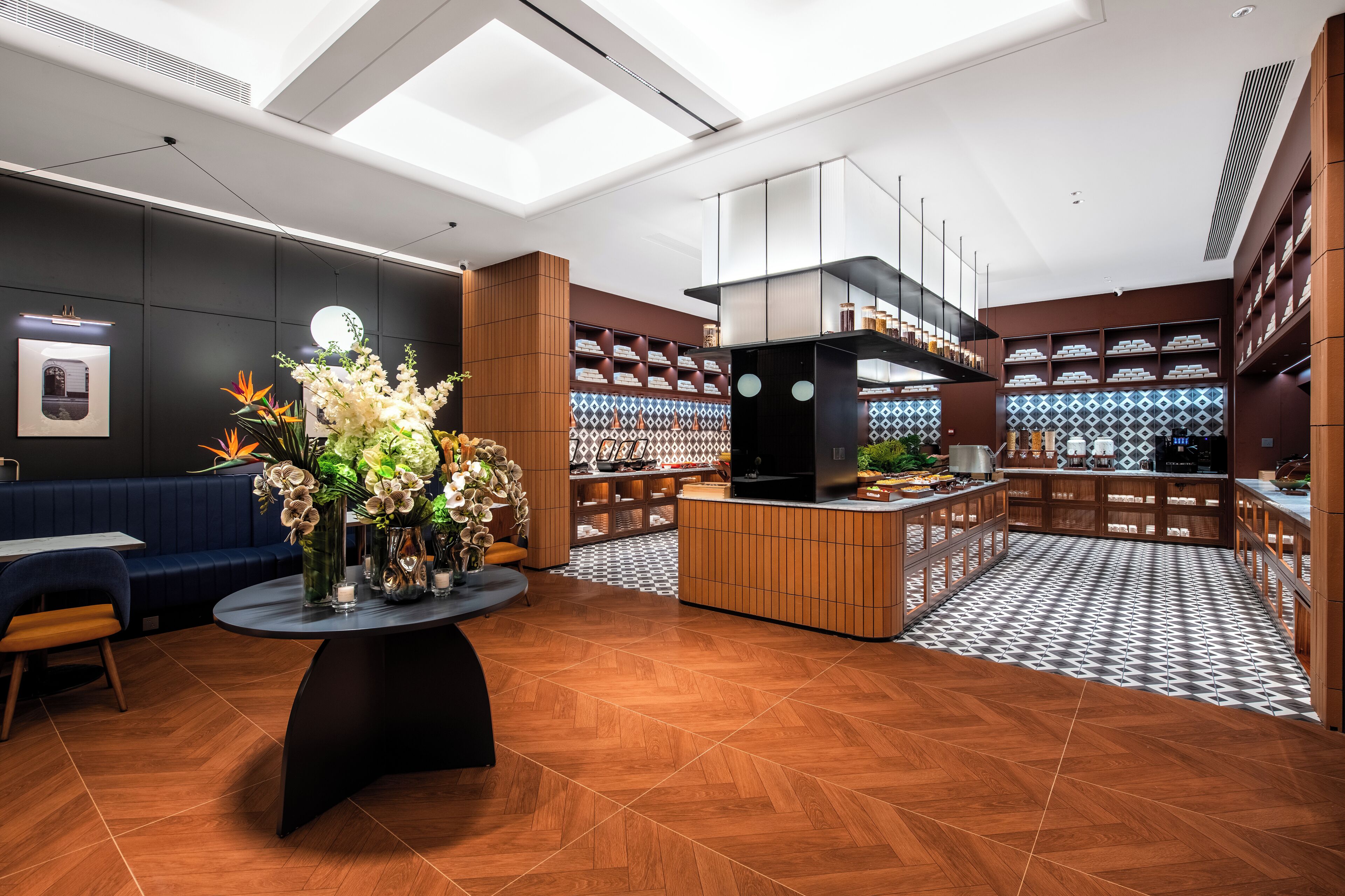 A modern interior with a central island, seating area, and a patterned floor.