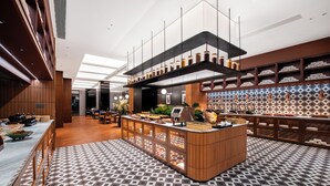 A modern kitchen with a central island, wooden cabinetry, and a patterned floor. - ZhongShan InterCity Expo Center Hotel (Zhongshan)