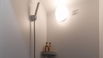 Eenvoudig appartement | Badkamer | Een douche, een haardroger, handdoeken, zeep