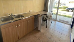 Eine Küche mit Holzausstattung, einer Arbeitsplatte und einem Essbereich mit einem Stuhl.