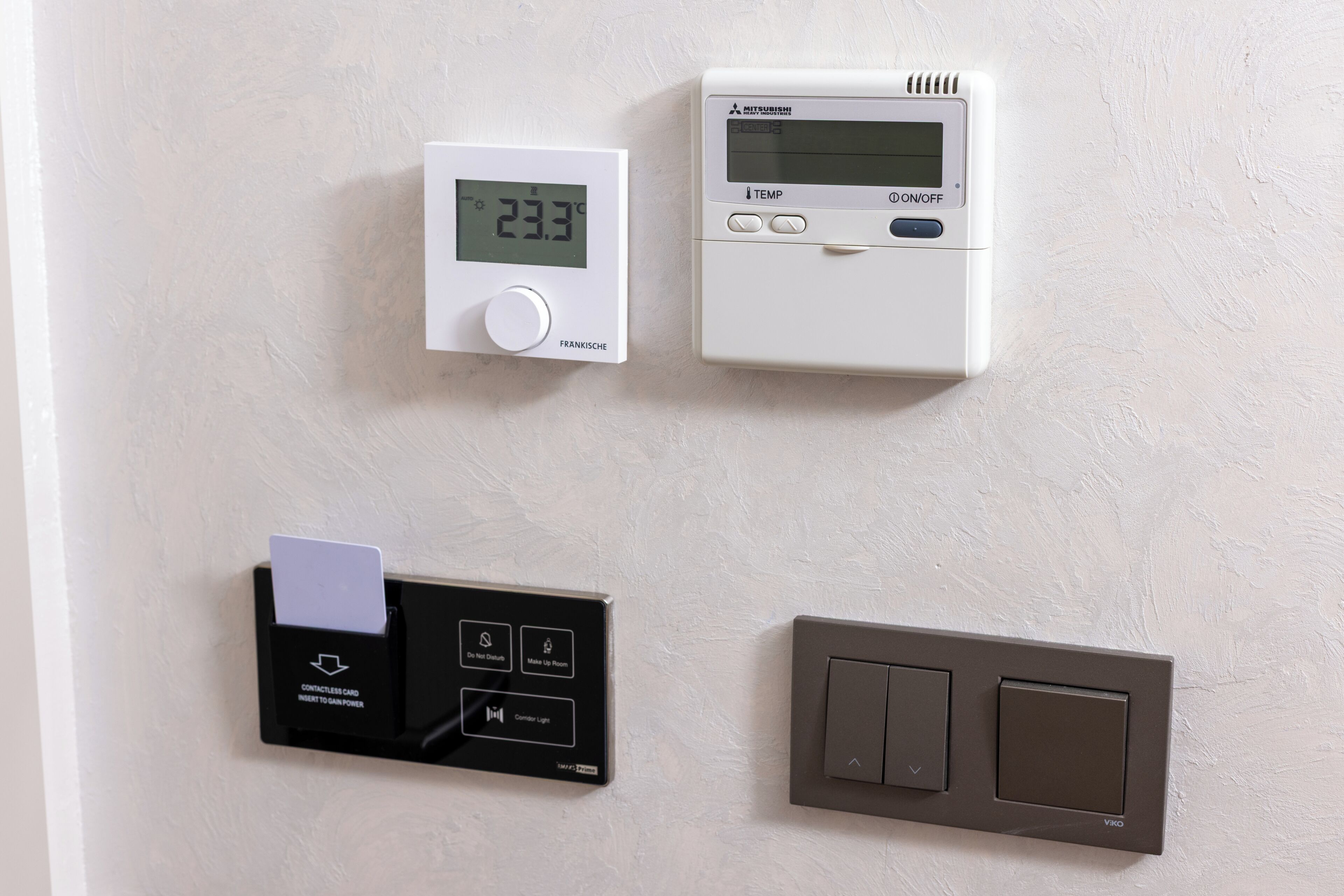 Ein Wandthermostat, ein Kartenlesegerät und ein Lichtschalter.