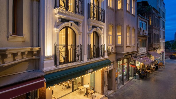 A historic building with ornate balconies and a ground-floor café. - Stern Hotel Karaköy (İstanbul)