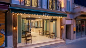 A restaurant with a green awning, outdoor seating, and a visible interior with a counter and chairs. - Stern Hotel Karaköy (İstanbul)