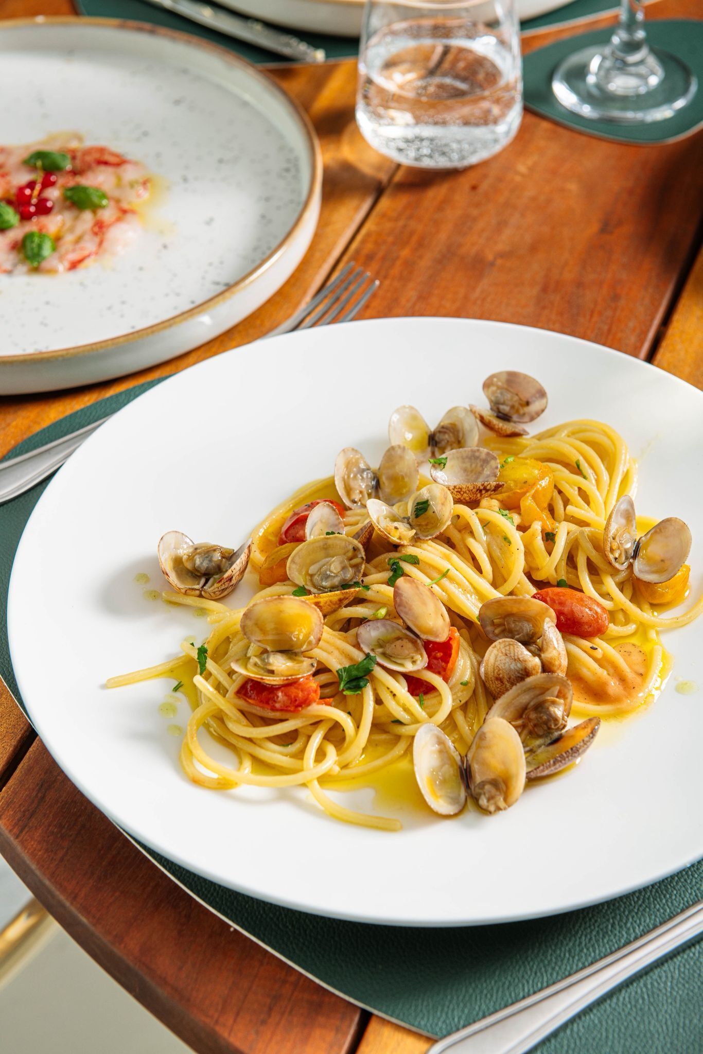 A plate of spaghetti with clams and tomatoes.