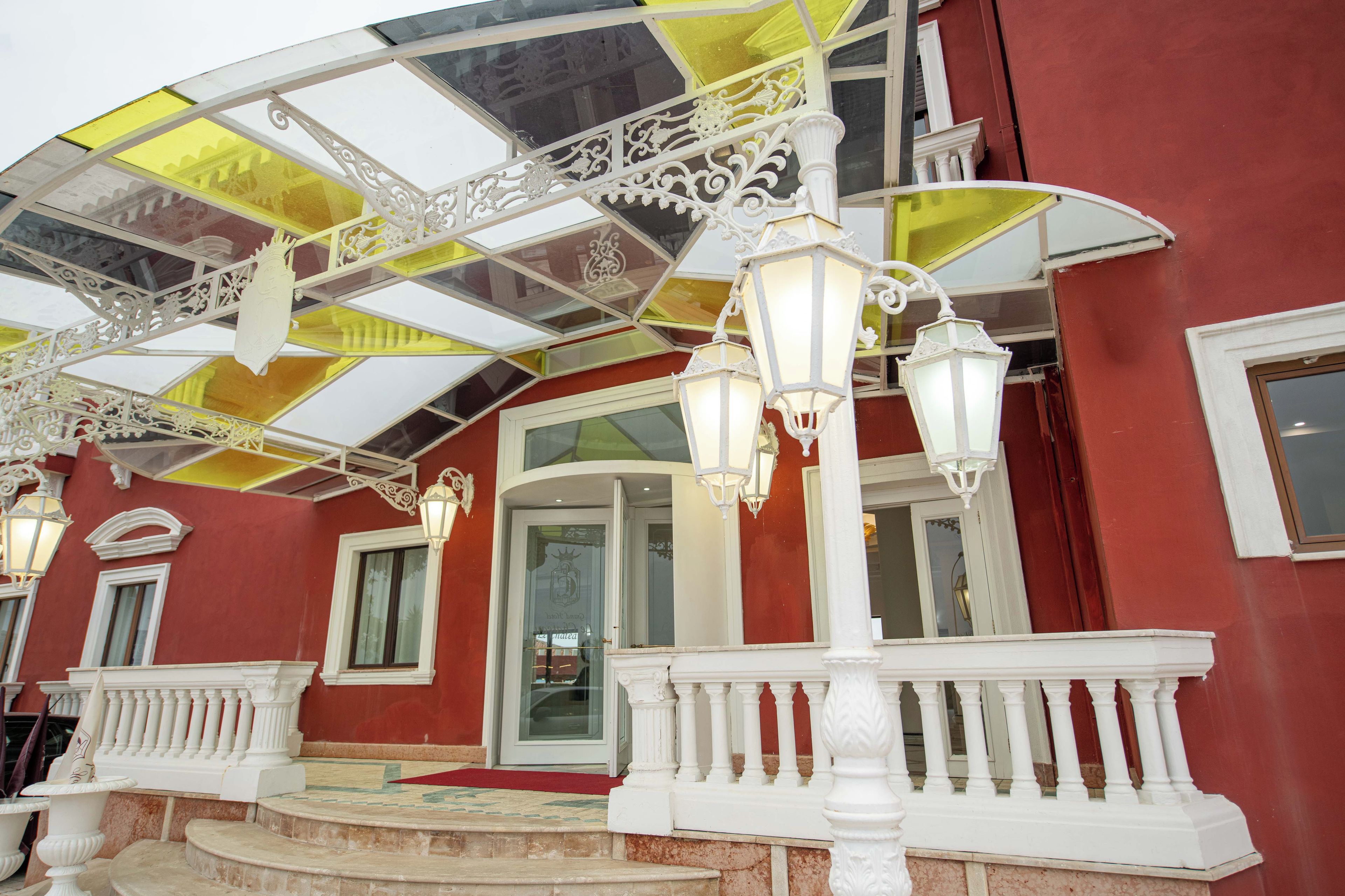 A building with a red exterior, white balconies, and a glass ceiling with yellow panels.