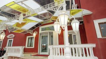 A building with a red exterior, white balconies, and a glass ceiling with yellow panels.