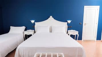 Ein Hotelzimmer mit einem großen Bett, zwei Nachttischen, einem Kleiderschrank und einer Tür.