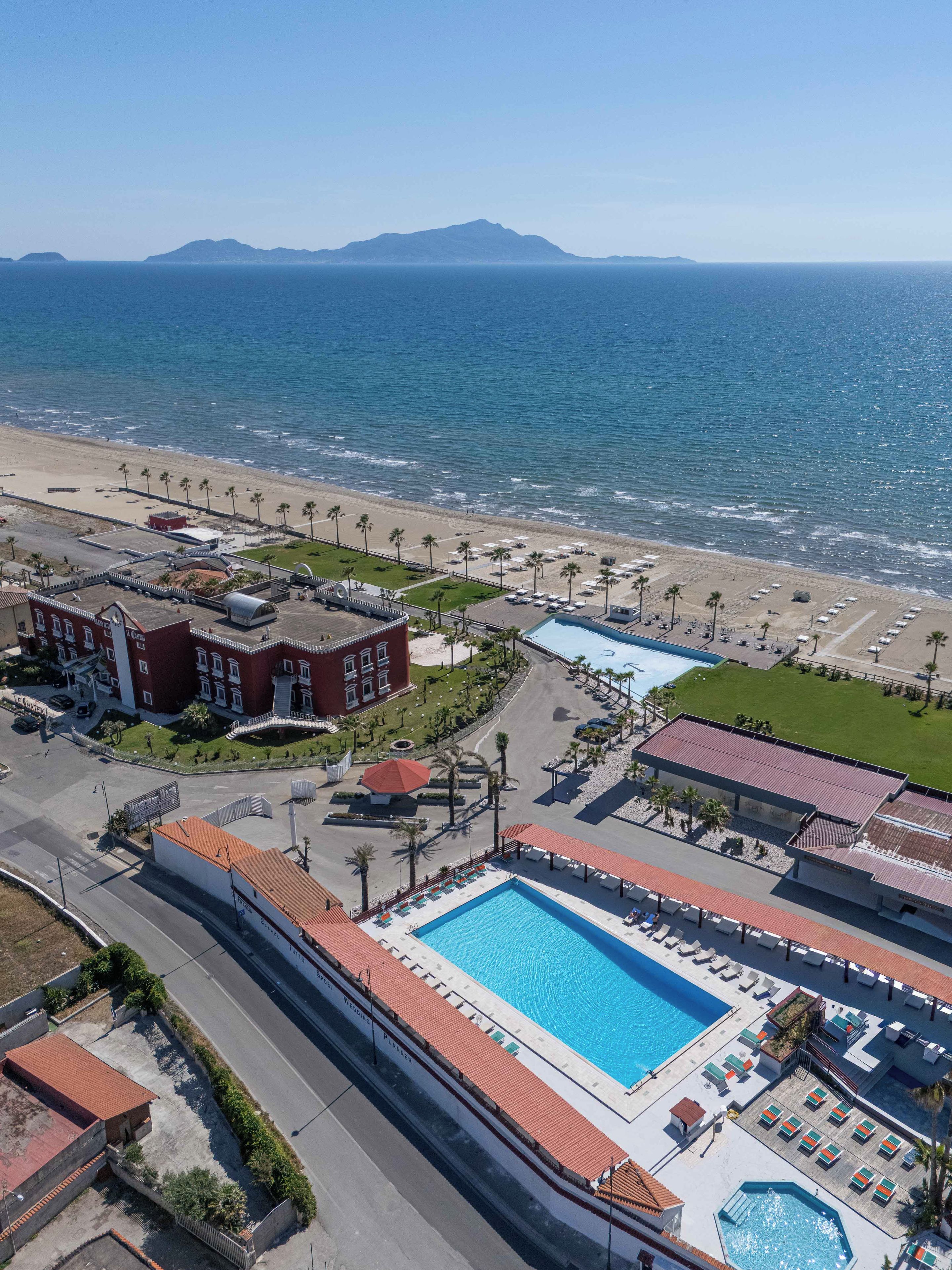 A resort with a swimming pool, beach access, and a view of the ocean.