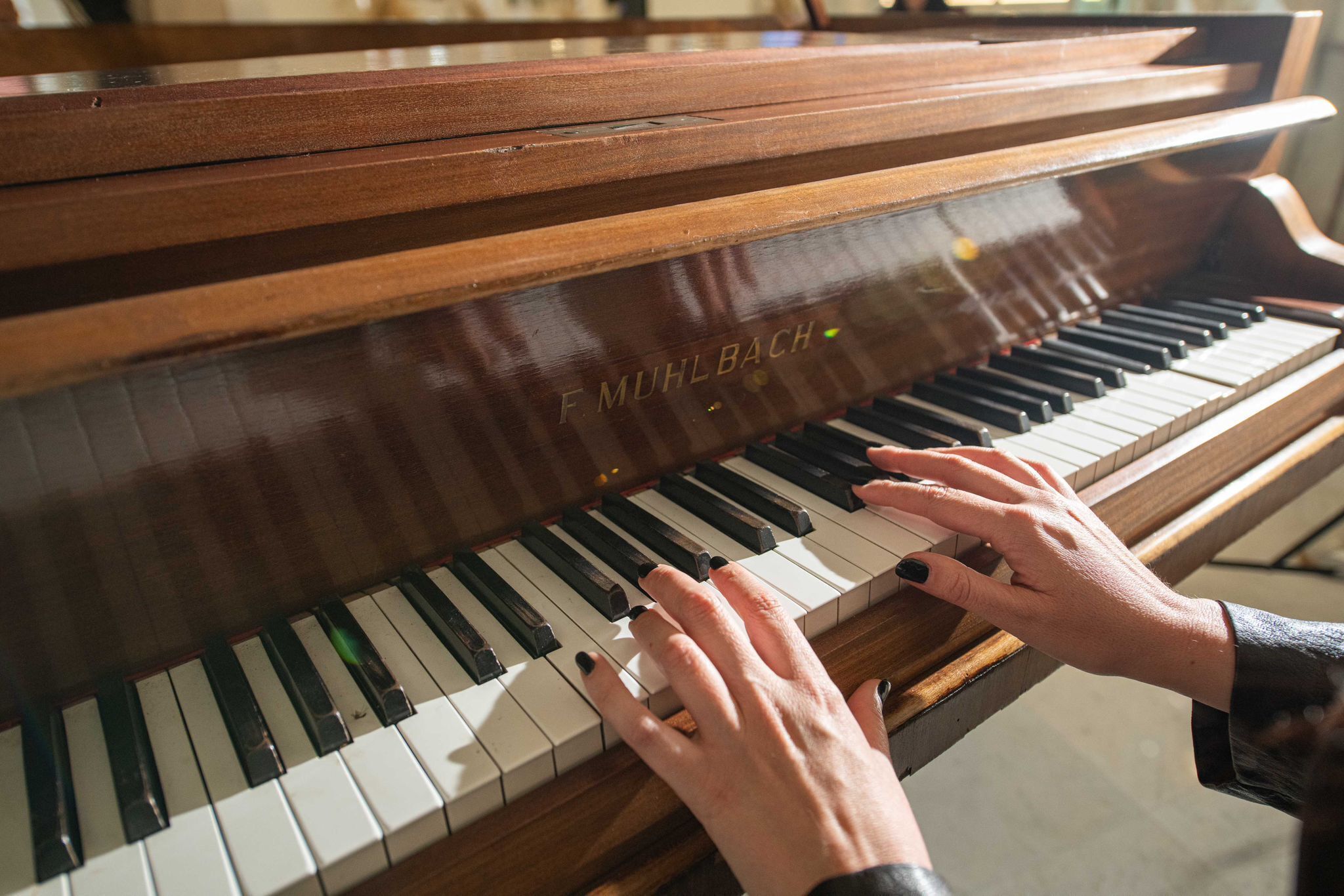 A grand piano with a person's hands playing it.
