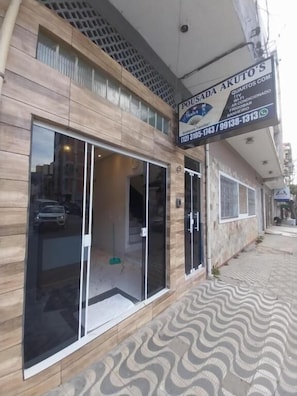 A building with a large glass window, a signboard, and a patterned floor.