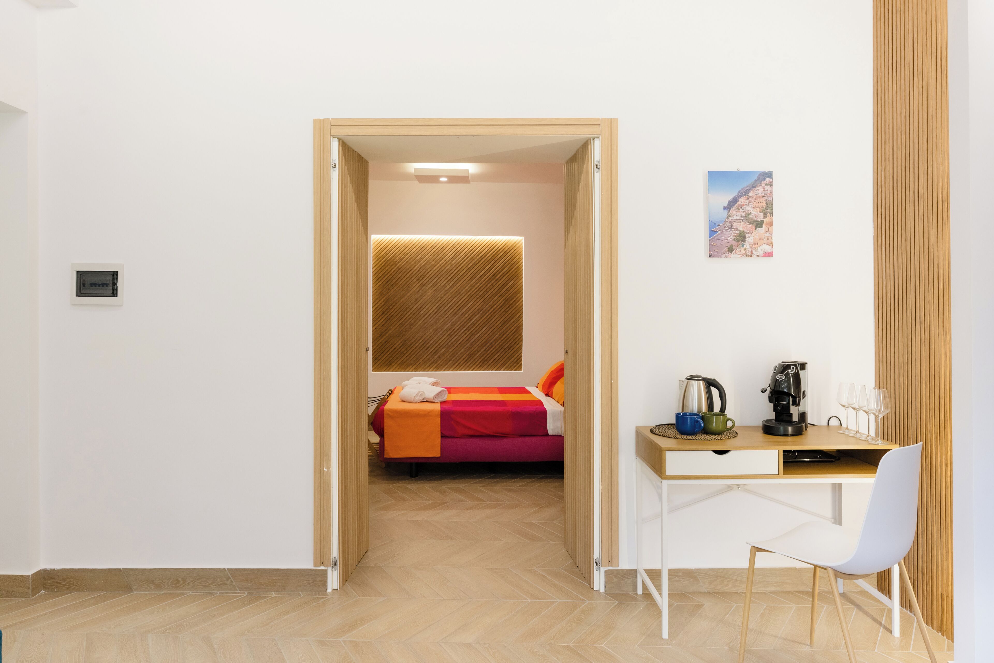 Ein Schlafzimmer mit Bett, Nachttisch und Schreibtisch mit Stuhl.