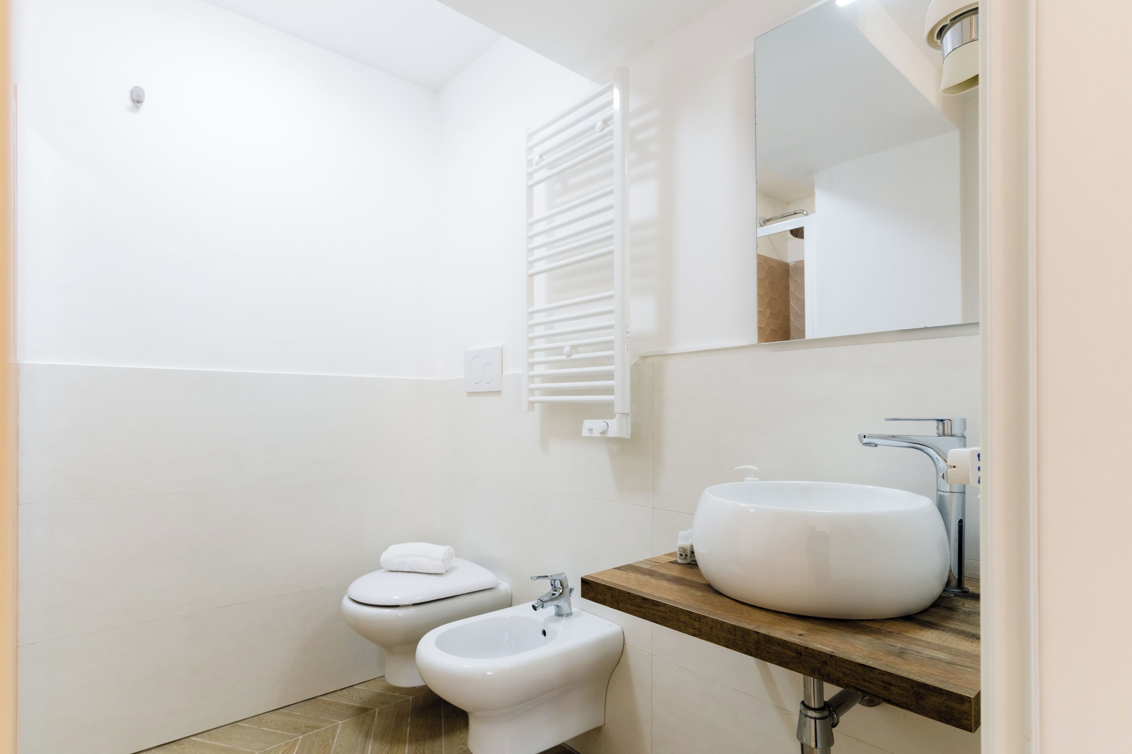 A modern bathroom with a toilet, bidet, and sink.