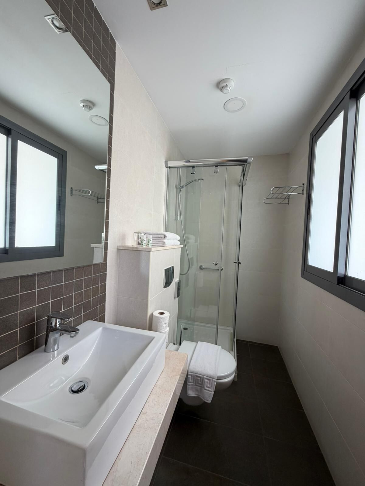 Ein modernes Badezimmer mit Badewanne, Toilette und einer Dusche in Glaswand.
