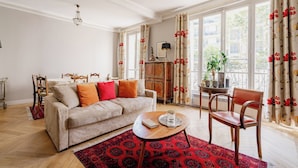 Een woonkamer met een bank, een bijzettafeltje en een stoel.