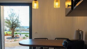 A dining area with a table, chairs, and a basket of pastries.