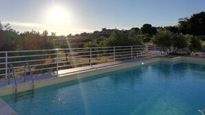 A swimming pool with a white fence, surrounded by trees and a clear sky. - CrauNari Agritourism and Educational Company (Modica)