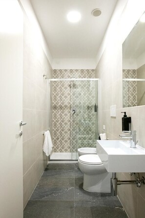 A narrow bathroom with a shower, toilet, and sink. - Camera Superior   Piazza Bologna (Roma)
