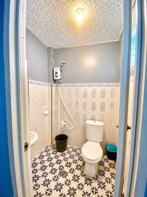 Et lille, kompakt badeværelse med toilet, bidet og bruser.