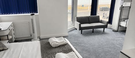 Una habitación de hotel con cama, sofá, escritorio y televisor.