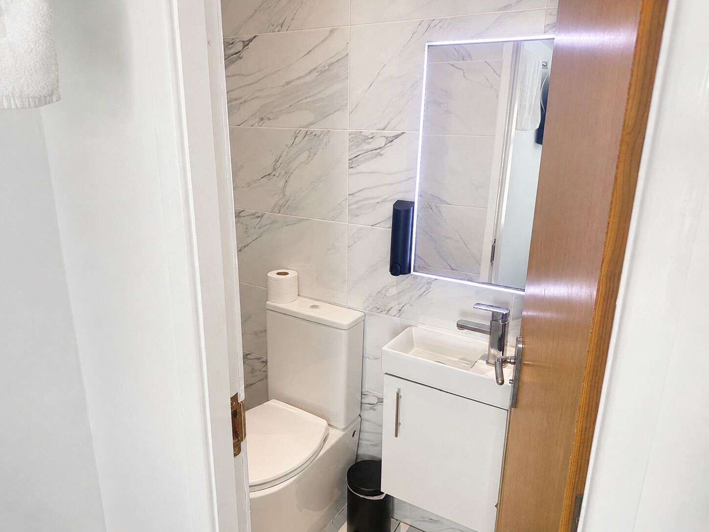 Ein Badezimmer mit Toilette, Waschbecken und Spiegel.