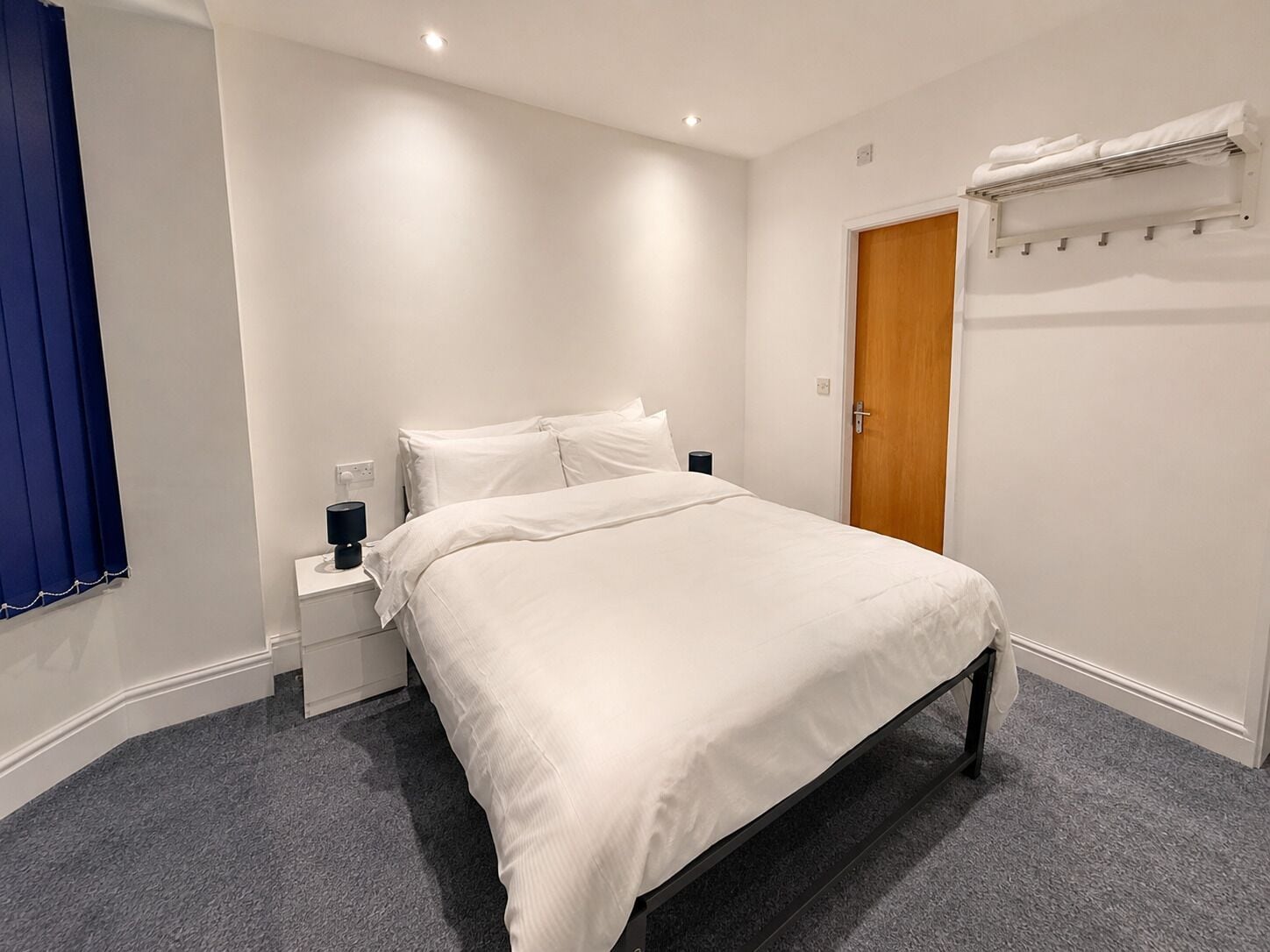 Une chambre bien rangée, avec un lit, une table de chevet et une armoire.