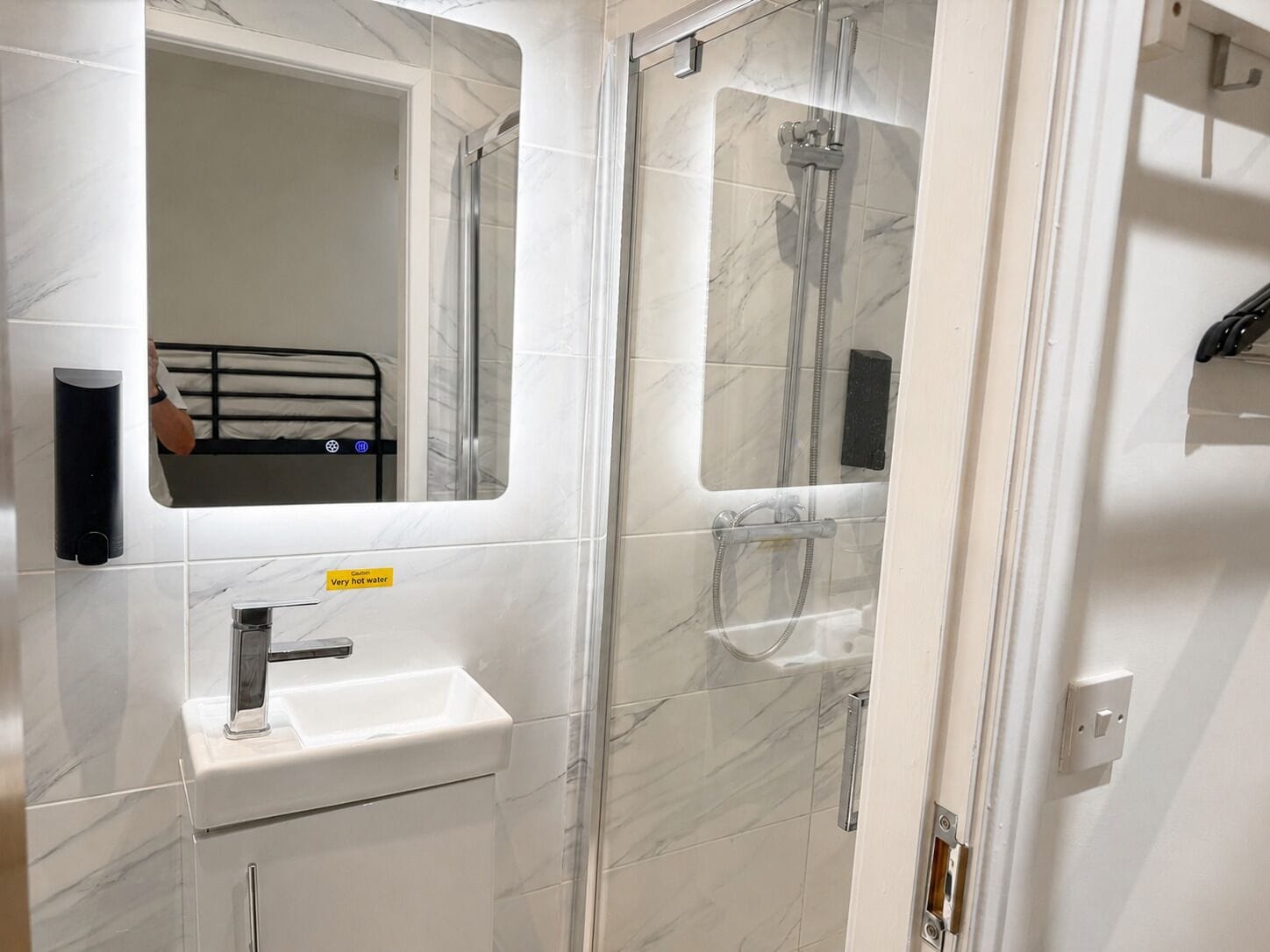 A bathroom with a white sink, a mirror, and a glass-enclosed shower area.