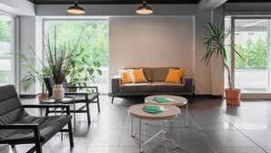 Un intérieur moderne avec un canapé, des fauteuils et des tables rondes.