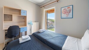 A bedroom with a bed, a desk, a chair, a radiator, and a picture on the wall. - Apartment 'Casa Verde Blu' with Balcony, Wi-Fi and Air Conditioning (Perivoli)