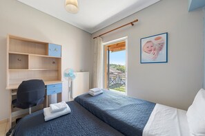 A bedroom with a bed, a desk, a chair, a radiator, and a picture on the wall. - Apartment 'Casa Verde Blu' with Balcony, Wi-Fi and Air Conditioning (Perivoli)