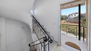 A staircase with a black railing leading to a balcony with a view of a residential area. - Apartment 'Casa Verde Blu' with Balcony, Wi-Fi and Air Conditioning (Perivoli)