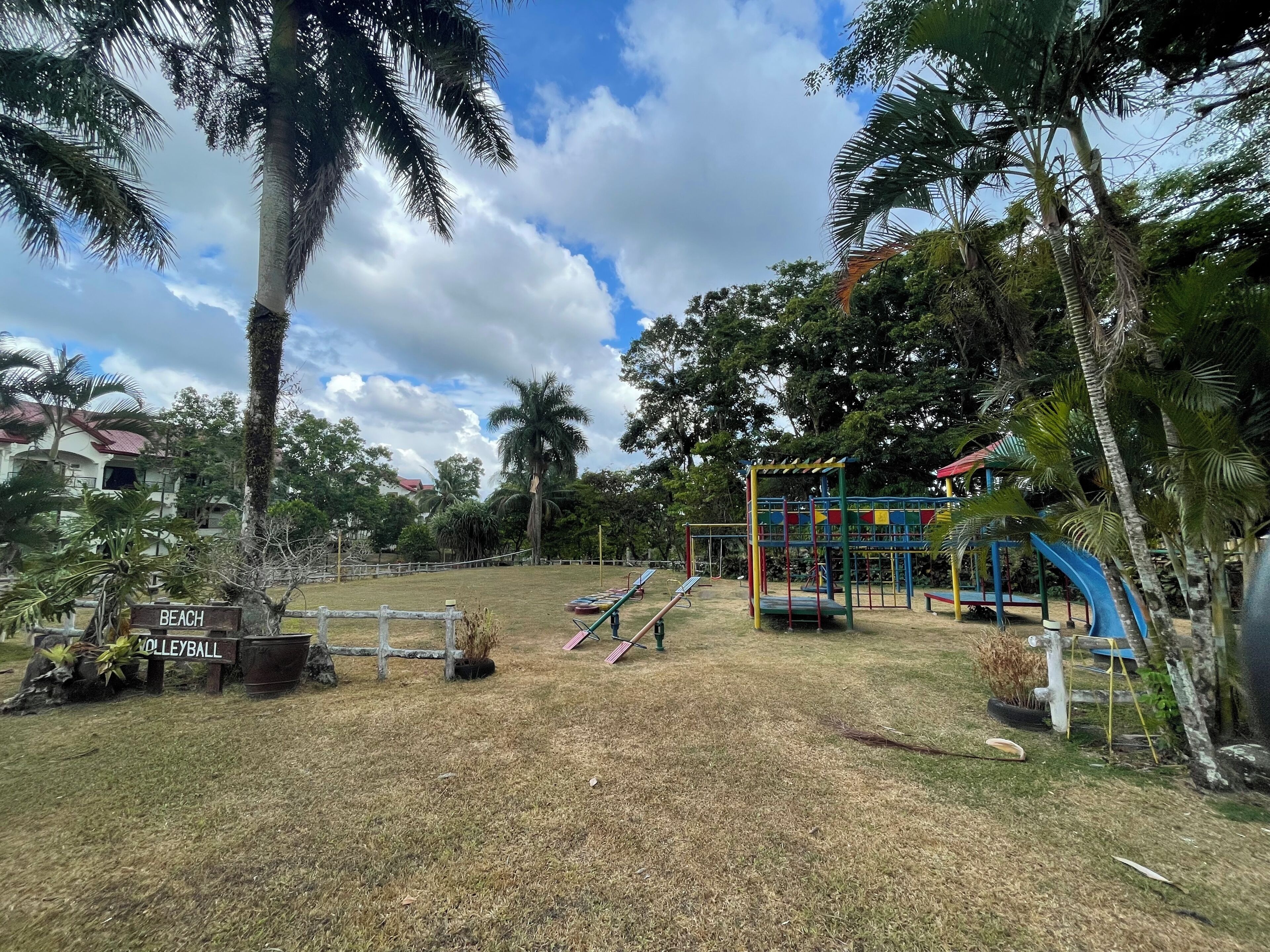 A playground with equipment, a 'BEACH' sign, and a 'VOLLEYBALL' sign.