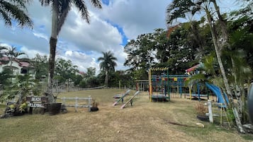 A playground with equipment, a 'BEACH' sign, and a 'VOLLEYBALL' sign.