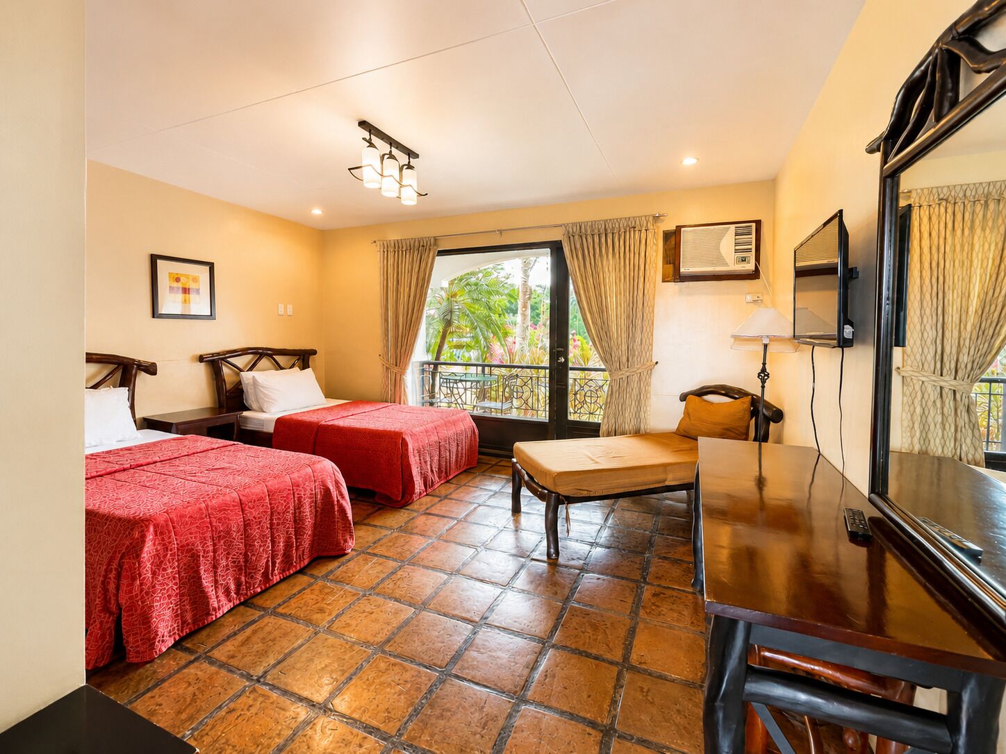 A hotel room with two beds, a desk, a chair, a TV, and a window with curtains.