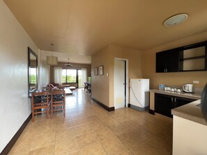 A spacious kitchen with a dining area, a refrigerator, and a view through the window.