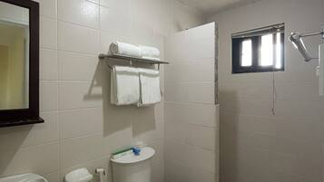 Un baño con inodoro, lavamanos y espejo.