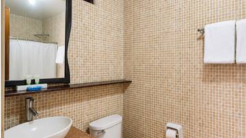 Un baño con lavamanos, inodoro y espejo.