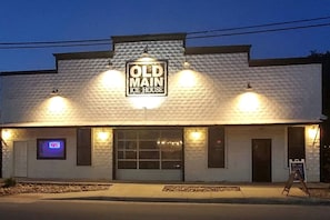 A building with a sign reading 'Old Main Ice House' and a neon 'OPEN' sign. - Discover Glamping at its Best in this Lovely Safari Tent Rental in the Heart of Texas (Cibolo)