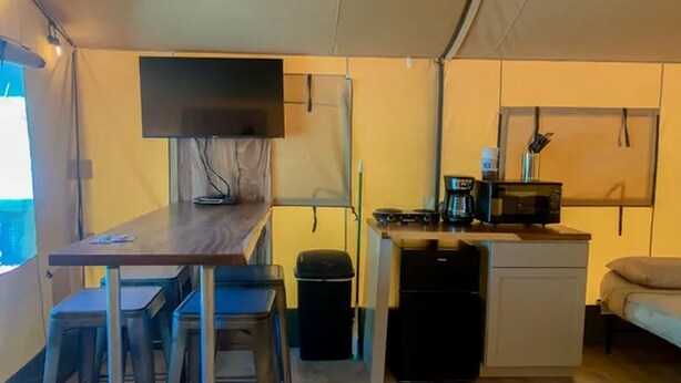 Une cuisine compacte comprenant un coin repas, un petit réfrigérateur et un four à micro-ondes.