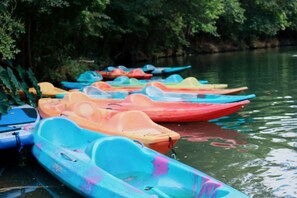 A row of colorful kayaks docked by a calm river. - Relaxing Family-Friendly Glamping Rental in Marion, Texas: Luxurious Safari Tent on the Cibolo Creek (Marion)