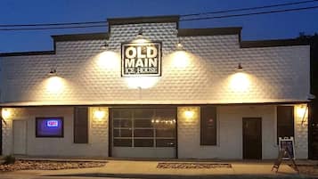 A building with a sign reading 'OLD MAIN ICE HOUSE' and a neon 'OPEN' sign.