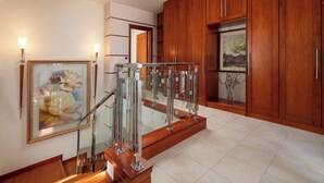 A modern kitchen with wooden cabinets, a glass railing, and a framed painting on the wall. - Casa di Vasia (Gennadi)