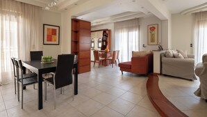 A spacious living area with a dining table, chairs, a sofa, and a bookshelf. - Casa di Vasia (Gennadi)
