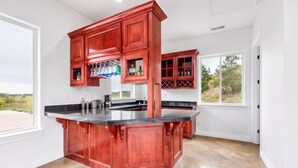 A kitchen with a central island, wooden cabinets, and a view of the outdoors.