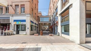 Eine Fußgängerzone mit Geschäften, einer überdachten Fläche und einem Gebäude mit einem großen Fenster.