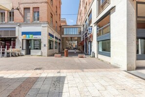 Eine Fußgängerzone mit Geschäften, einer überdachten Fläche und einem Gebäude mit einem großen Fenster.