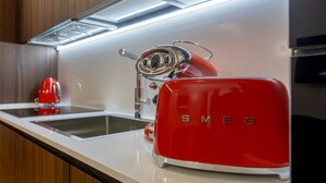 Eine K üche mit einem roten SMEG-Toaster, einer roten Kaffeemaschine und einer Spüle aus Edelstahl.